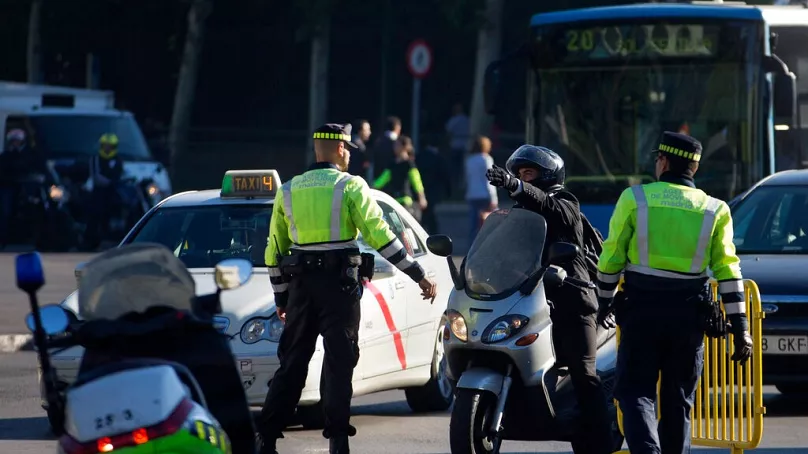 FILE: A motorcyclist argues with police after they cut the main Gran Via boulevard to private traffic, during the European Car Free Day in Madrid, Spain, Sept. 22, 2015