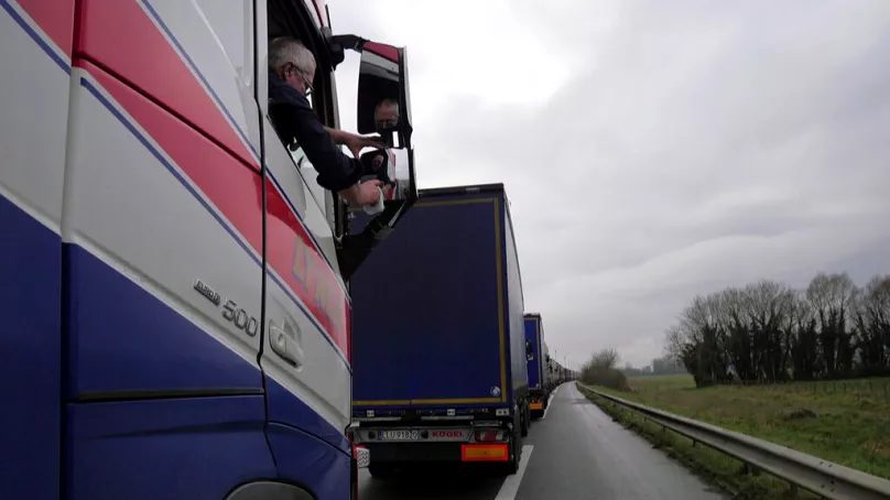 FILE: A British lorry driver cleans a wing mirror as he queues along the A16 motorway to board a ferry to reach England, near Calais, northern France, Dec. 9 2020