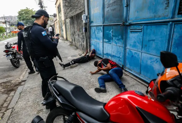 Agentes de policía de Río de Janeiro custodian a dos personas tiradas en el suelo durante el operativo.
