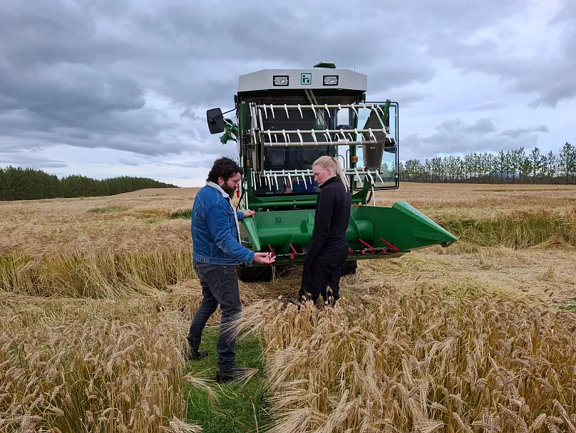 Hrannar Smári Hilmarsson and a mini harvester driver in a barley field
