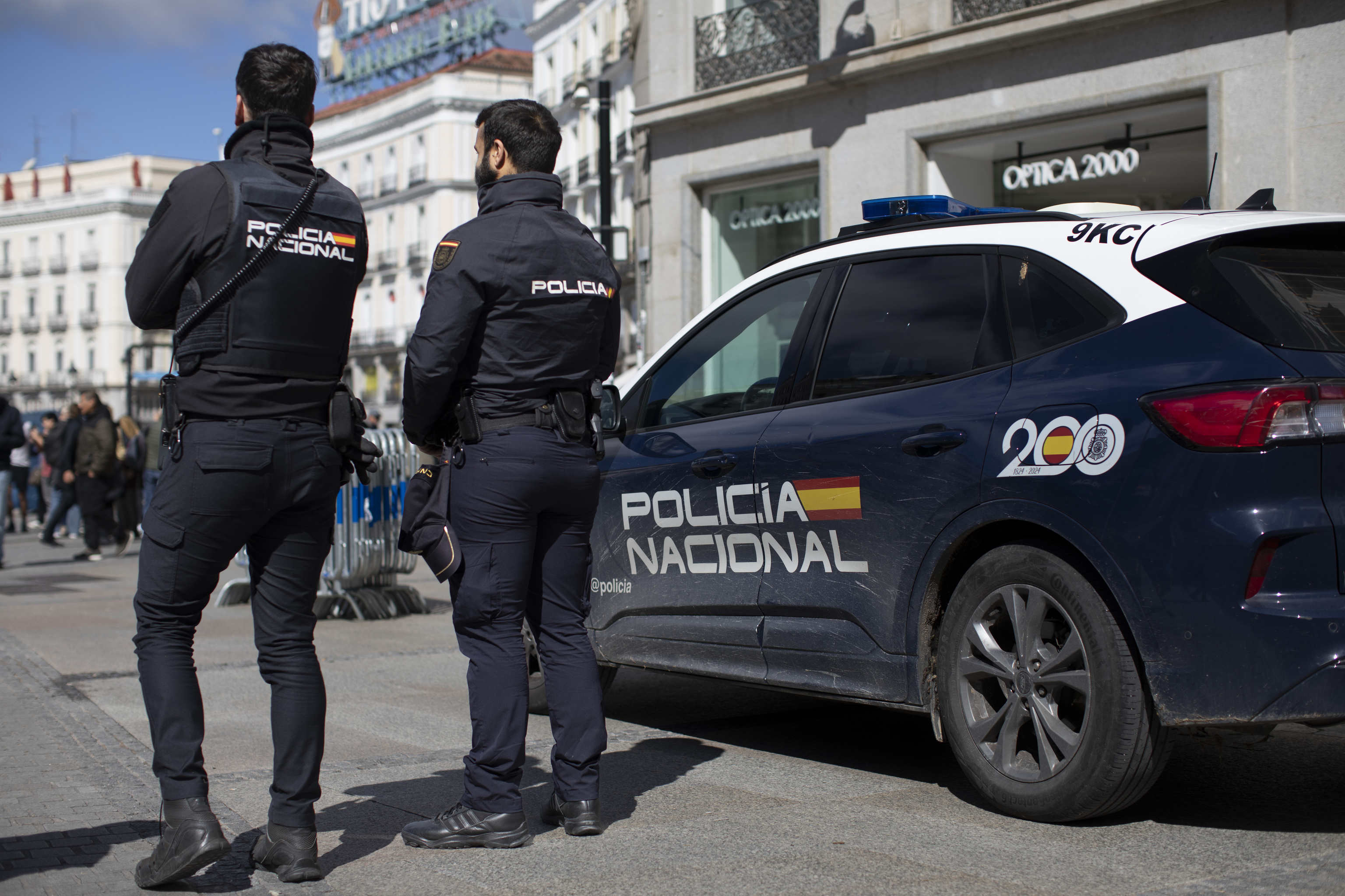 Un coche de Policía y dos agentes.