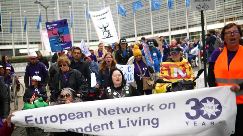 FILE: People gather outside the European Commission headquarters in Brussels, Wednesday, Oct. 2, 2019, demanding better independent living support for disabled people. 