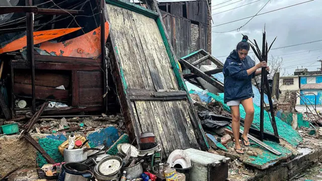 Personas juntando sus pertenencias tras el paso del huracán Melissa por Santiago de Cuba.