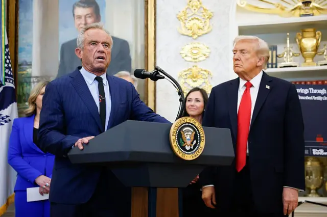 Robert F. Kennedy Jr. habla desde un podio en el Despacho Oval bajo la mirada atenta del presidente Trump.