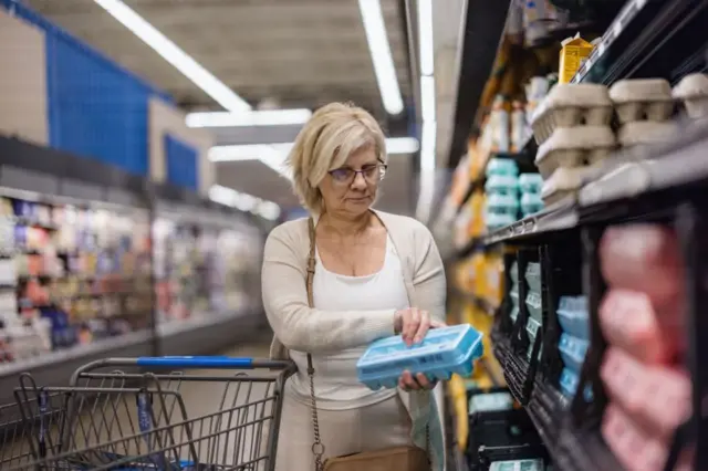 Señora comprando huevos