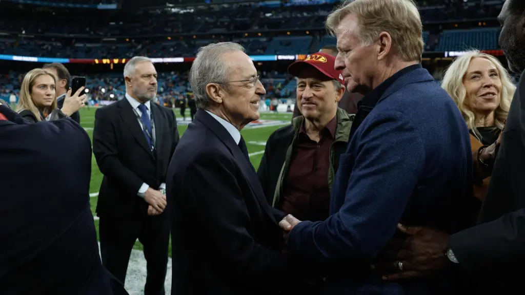 El presidente del Real Madrid, Florentino Pérez, saluda a Roger Goodell (d), comisionado de la NFL, junto al propietario de los Washington Commanders, Josh Harris (2d, con gorra), antes del partido de liga regular de la Liga de Fútbol Americano (NFL) que este domingo disputan los equipos Miami Dolphins (d) y Washington Commanders en el Estadio Santiago Bernabéu.