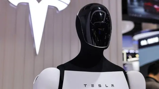 Un robot Tesla Optimus junto a un logotipo en el stand de la compañía en la 8ª Exposición Internacional de Importaciones de China en Shanghái, China.