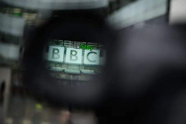 El logo de la BBC en su edificio principal de Londres, visto a través del visor de una cámara.