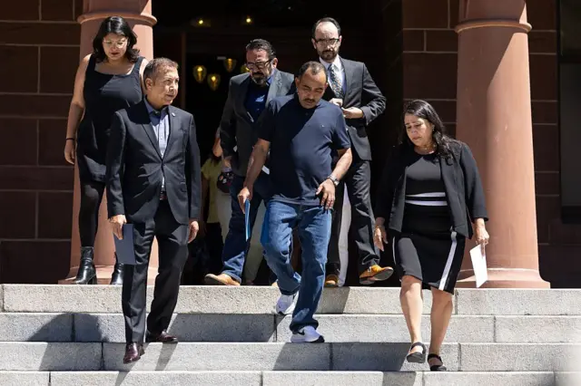 Narciso Barranco, flanqueado por su familia y líderes comunitarios, baja los escalones antes de una conferencia de prensa en el Antiguo Palacio de Justicia del Condado de Orange el viernes 25 de julio de 2025 en Santa Ana, CA. (Luke Johnson / Los Angeles Times vía Getty Images)