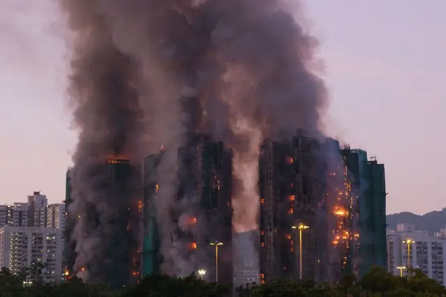 Una panorámica de varios edificios envueltos en denso humo y llamas en sus diferentes pisos