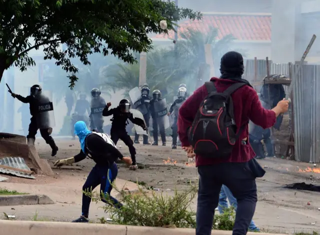 Unos estudiantes se enfrentan a la policía en unas protestas en Tegucigalpa.