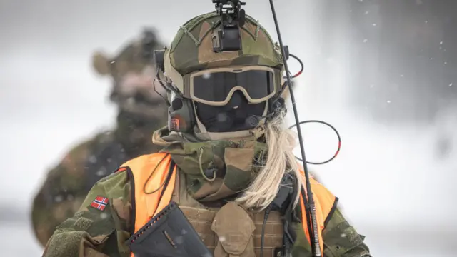Soldado noruego femenino (no recluta) con mascarilla, en un día nevado.