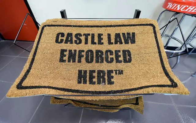 Una alfombra de puerta que dice "Aquí se aplica la ley del castillo".