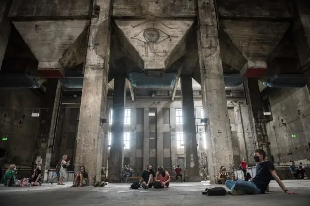 Visitantes escuchan la instalación sonora "eleven songs halle am berghain" en el club Berghain que fue concebida durante la pandemia en 2020.
