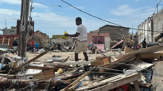 Un hombre camina entre los escombros de Black River