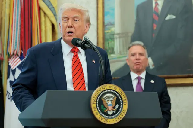 Donald Trump habla en un podio en el Despacho Oval, con Steve Witkoff parado detrás de él