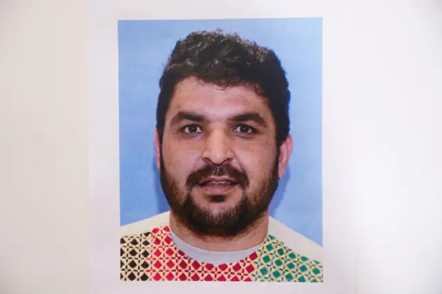 Una foto de frente de Rahmanullah Lakanwal, quien viste una camiseta con rombos de varios colores