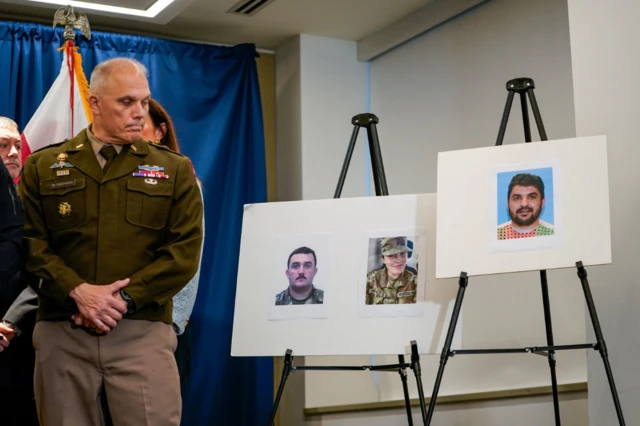 Un funcionario federal mira los retratos de las dos víctimas y el sospechoso presentadas en una rueda de prensa.