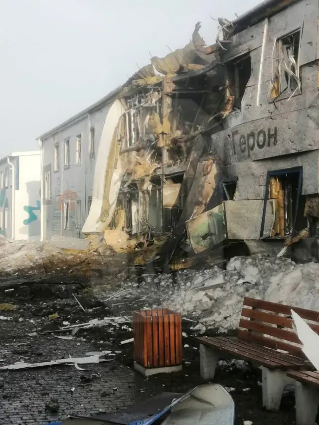 Un edificio de dos pisos, con textos en ruso en la fachada, destruido por una explosión.
