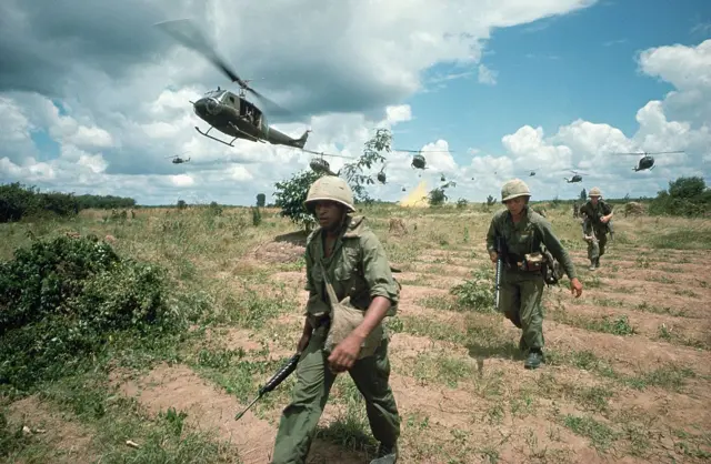 Soldados estadounidenses en Vietnam caminando por un campo.