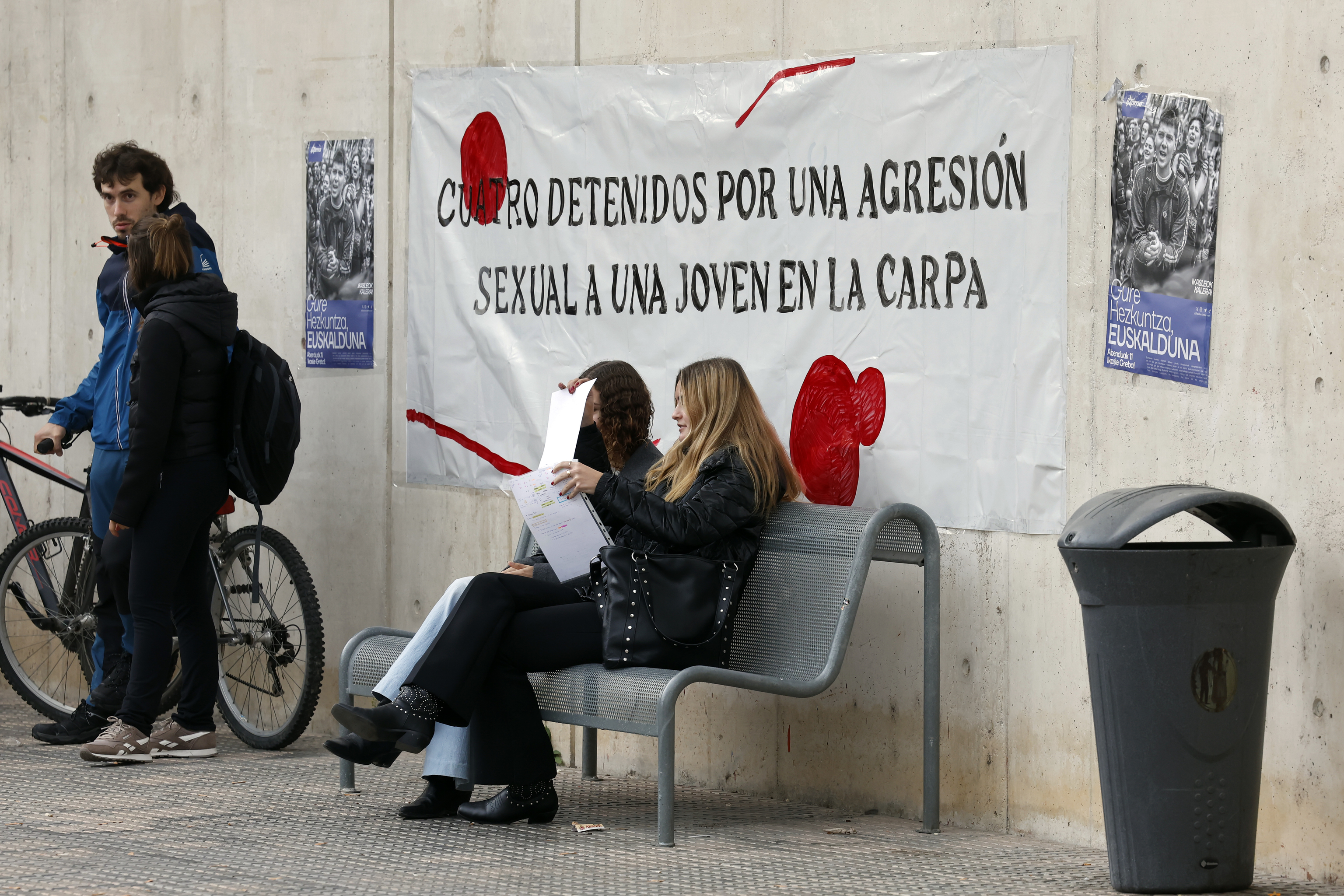 Varios estudiantes, ayer, junto a una de las pancartas que denuncian la violación sufrida por una compañera de la Universidad Pública de Navarra.