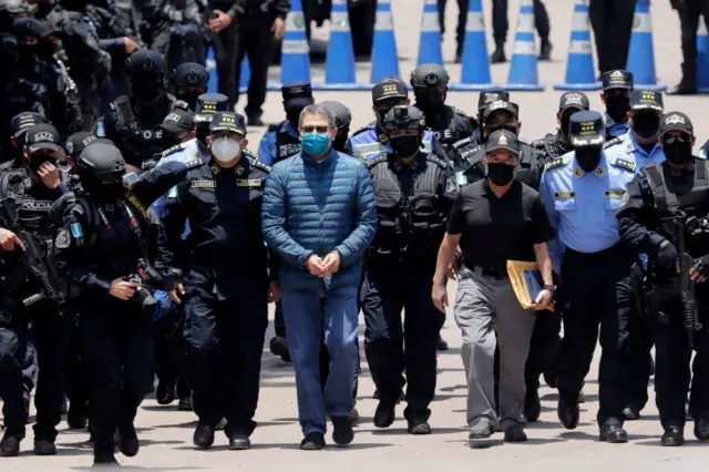 Momento del traslado de Hernández esposado y rodeado de muchos policías, algunos con chalecos antibalas