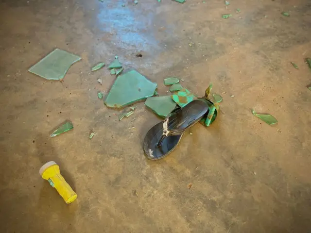 Una sandalia junto a una antorcha y fragmentos de cristal roto en un dormitorio con camas del internado St Mary's, en la aldea de Papiri, en el estado de Níger. 