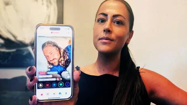 Una foto de Nadia sosteniendo su teléfono donde se ve el perfil de Tinder de Harkins.