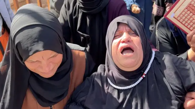 Familiares de los fallecidos expresan su dolor durante el funeral.