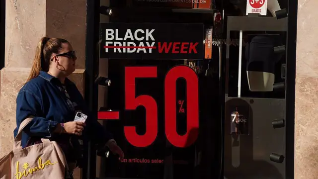Un cartel que muestra un descuento de hasta el 50% en una tienda de Madrid.