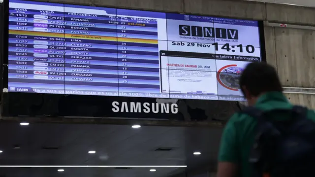 Un hombre ve la pantalla de información del aeropuerto de Maiquetía.