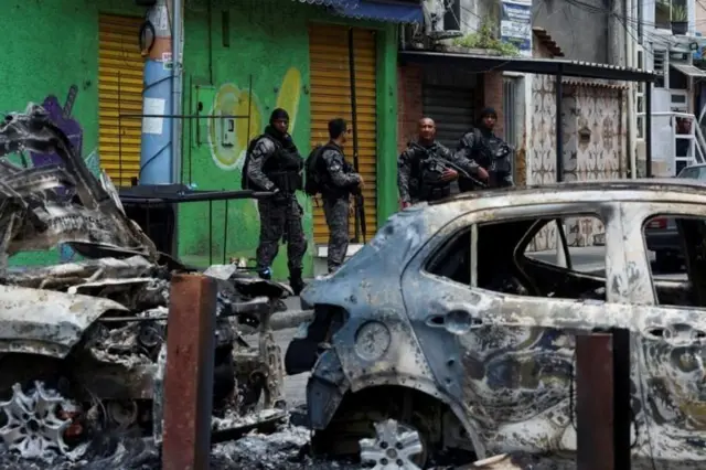 Vehículos quemados en barricadas durante una operación policial en Brasil.