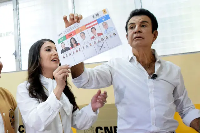 Salvador Nasralla sostiene la papeleta con su voto, con una cruz debajo de su foto, y a su lado también sostiene la boleta su esposa, Iroska Elvir.