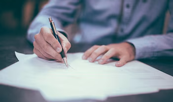 Una persona firma los documentos