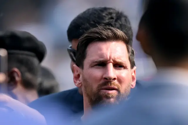 Lionel Messi se ve rodeado de funcionarios y famosos que bloquean la vista del público.