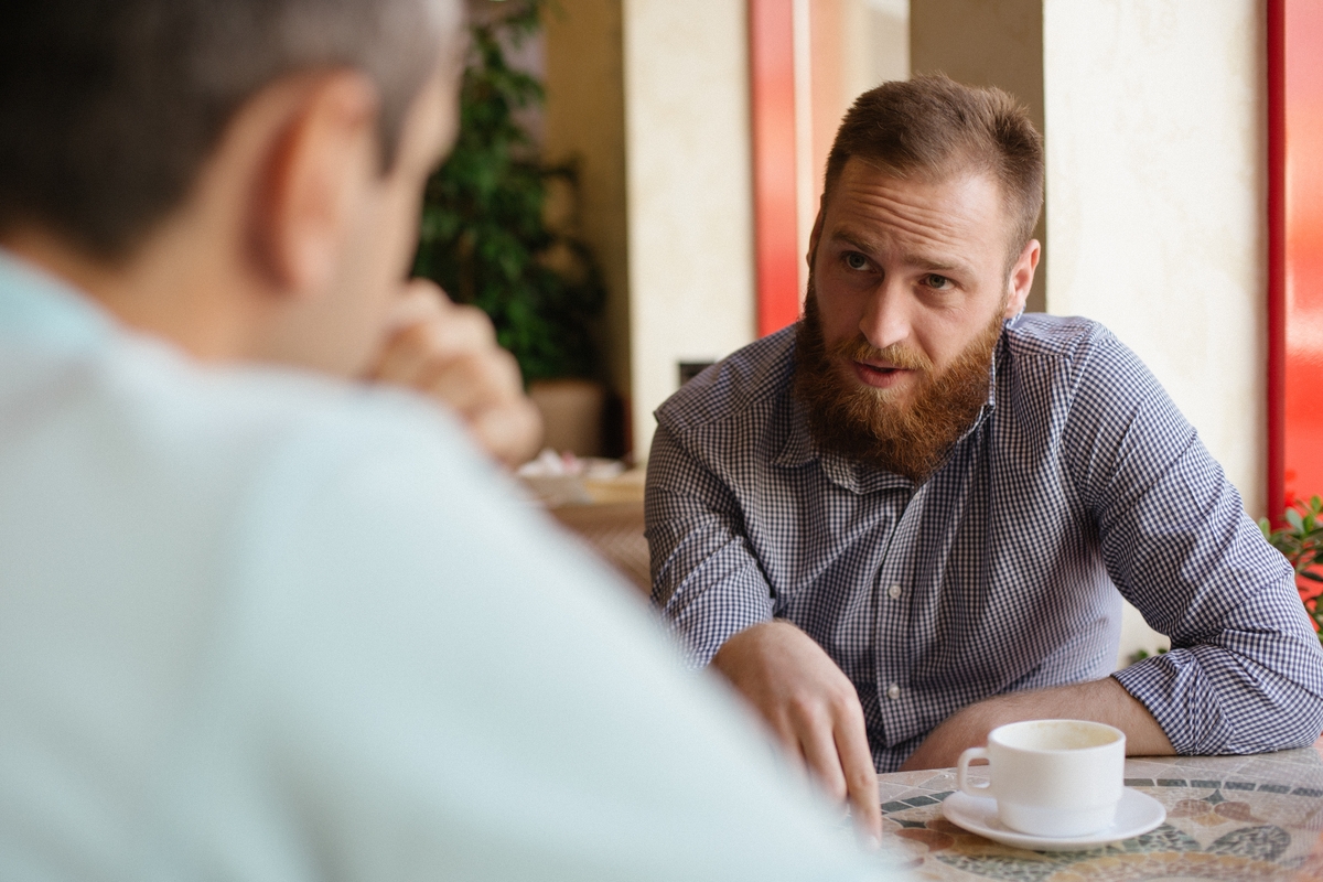 Dos amigos hablando (AdobeStock)