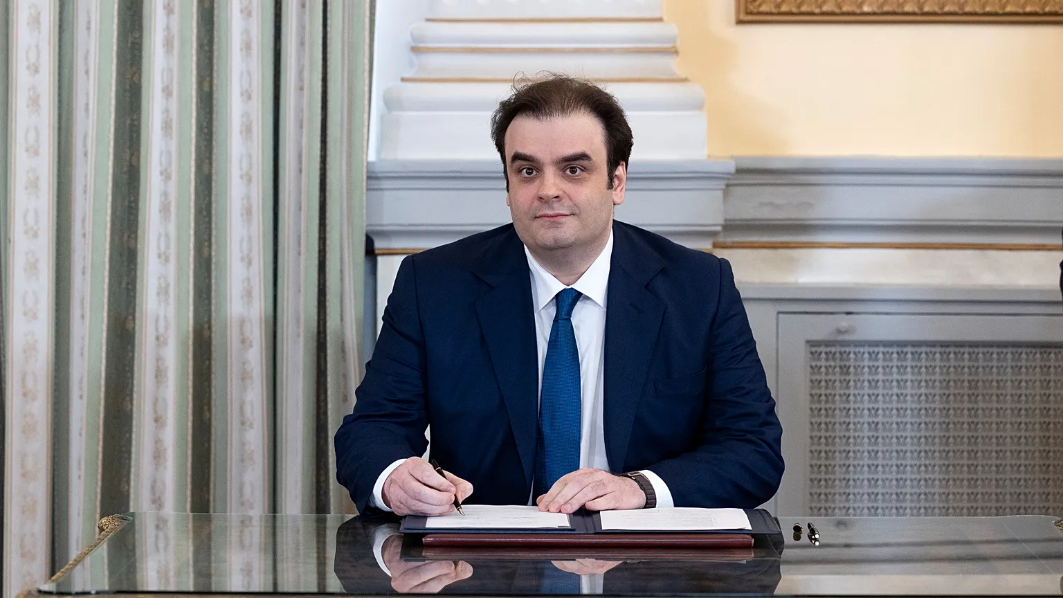 Greece's newly appointed Finance Minister Kyriakos Pierrakakis, signs a document following a swearing in ceremony at the Presidential palace, in Athens, March 15, 2025