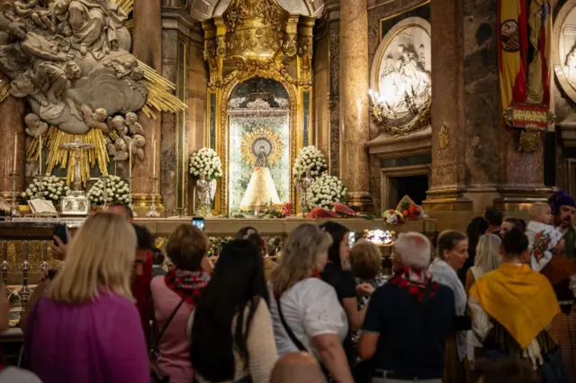 Feligreses rezando ante la Virgen del Pilar en Zaragoza (España).