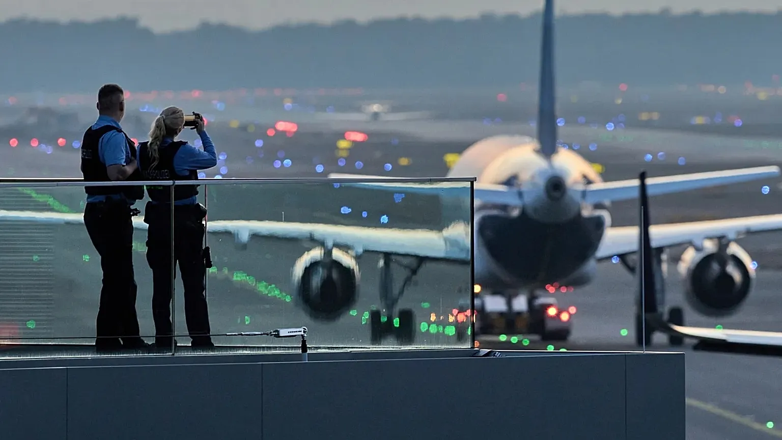 Police officers watch aircraft take their parking positions at the airport in Frankfurt, Germany.