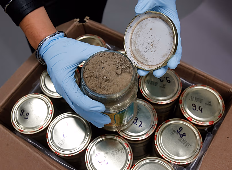 A criminal expert displays glass jars with heroin at the headquarters of the federal police in Wiesbaden, 9 October, 2014