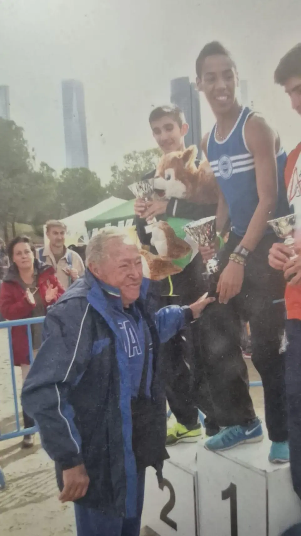 Jesús Hurtado acompaña a su hijo en un podio de una carrera.