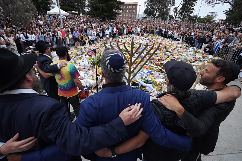 Mourners gather at a menorah lighting ceremony at a floral memorial for victims of the Bondi Beach shooting, 16 December, 2025