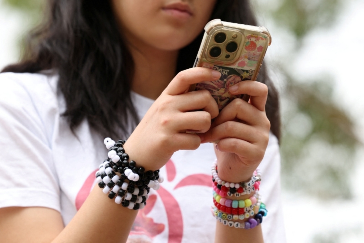 Joven utilizando un teléfono (REUTERS/Hollie