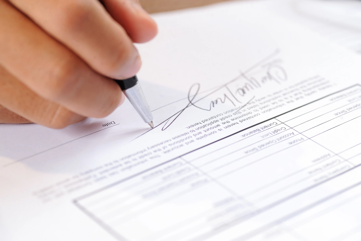 Un persona firmando un documento