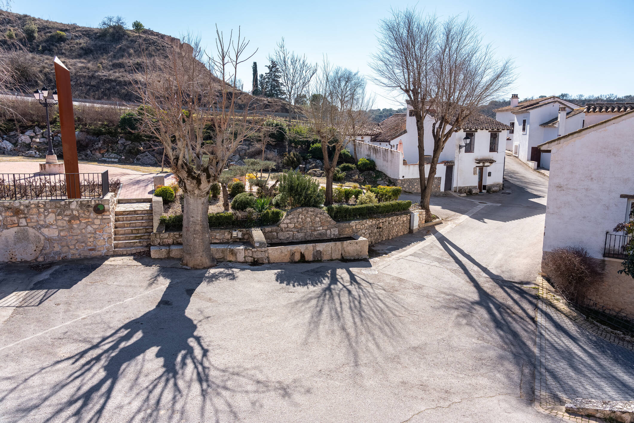Foto: Imagen del centro del pueblo, con una pequeña plaza empedrada y casas encaladas. (iStock)