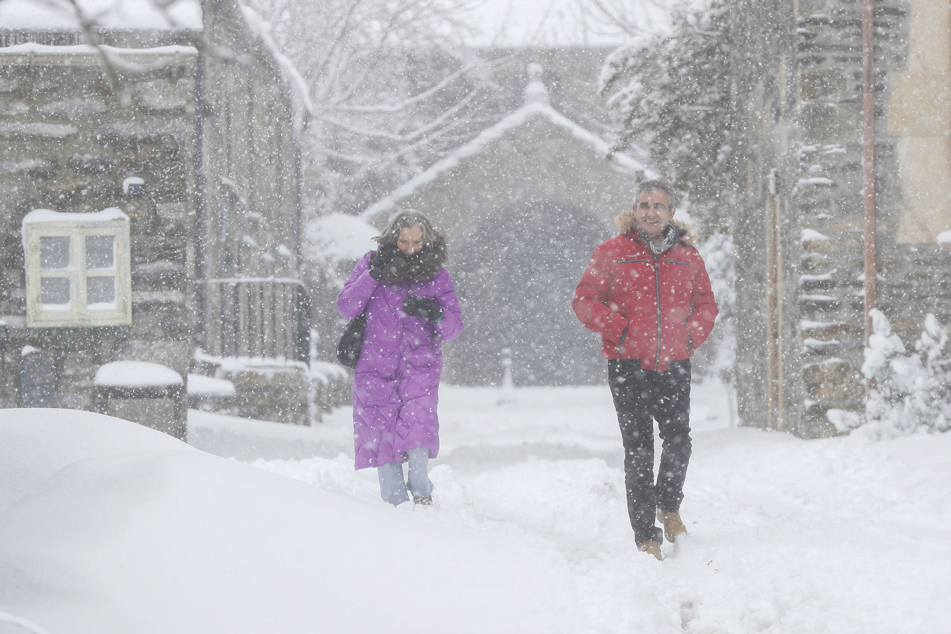 Dos personas caminan en el municipio lucense de Pedrafita do Cebreiro durante la fuerte nevada del miércoles.