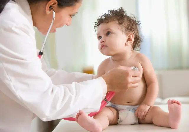 Un bebé siendo examinado por una doctora