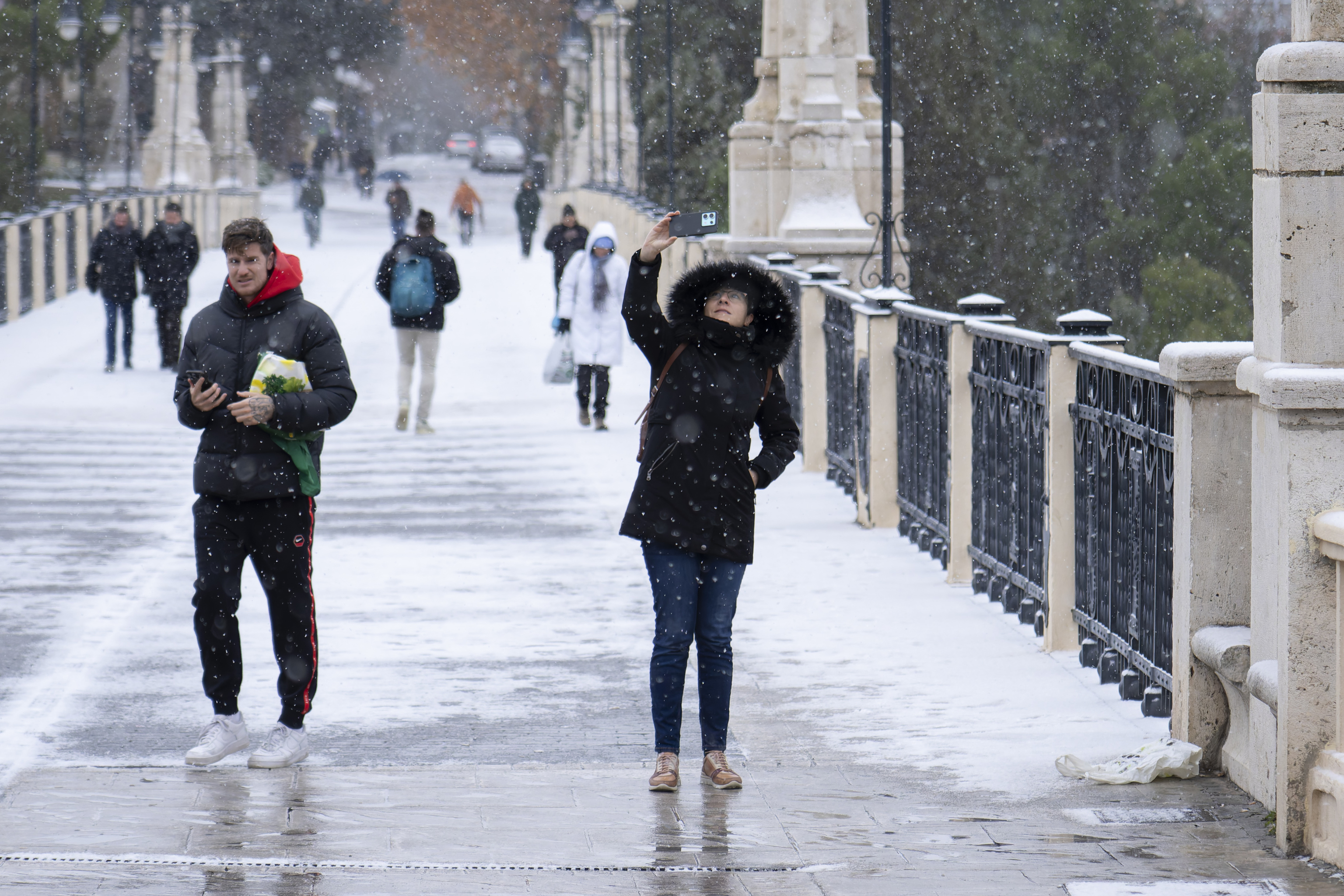 Varias personas caminan por Teruel bajo la nevada.