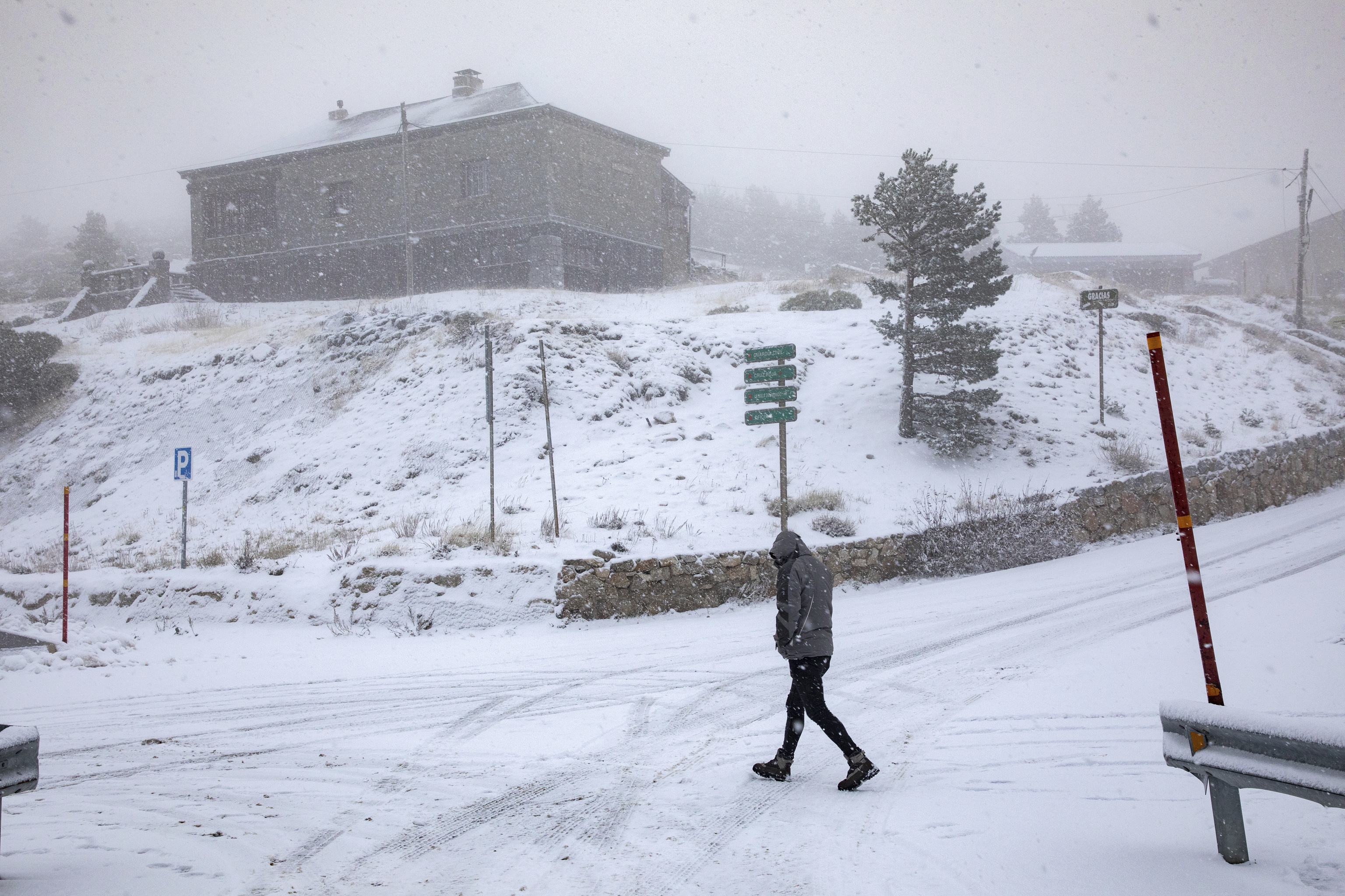 Un hombre camina mientras nieva en el Puerto de Navacerrada, entre Madrid y Segovia.