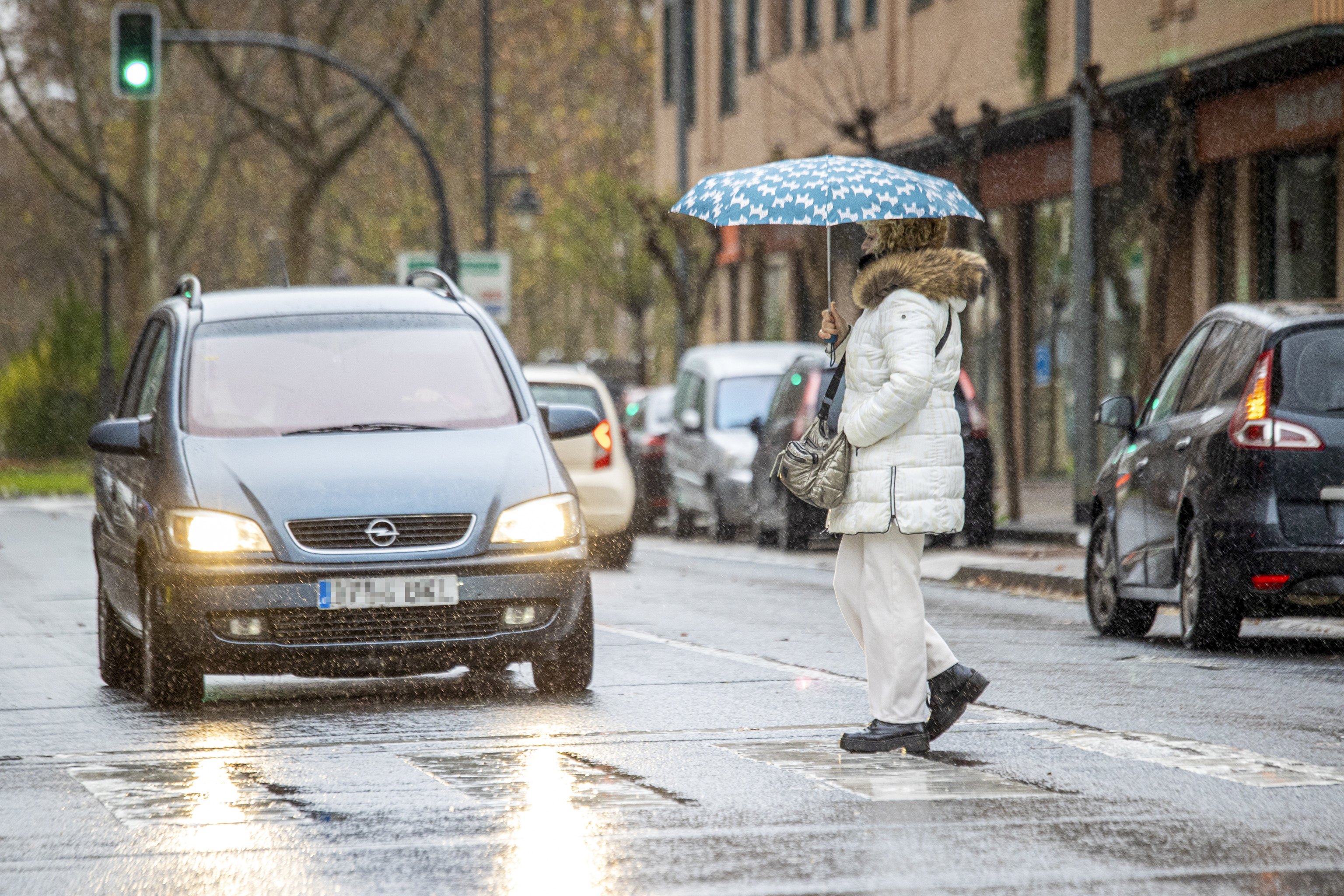 Una mujer cruza la calle bajo la lluvia en Logroño